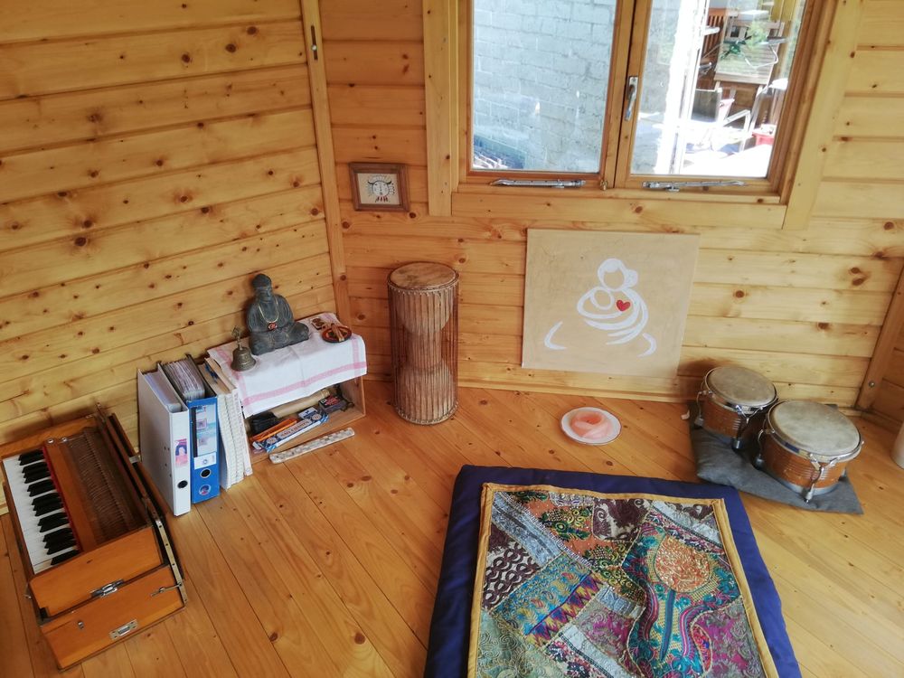 Harmonium, Buddha-Figur und Trommeln in einer Ecke des Pavillons